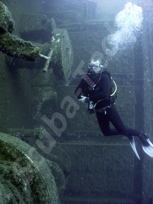scuba diver hovers at the Zenobia's bow among the winches and anchors